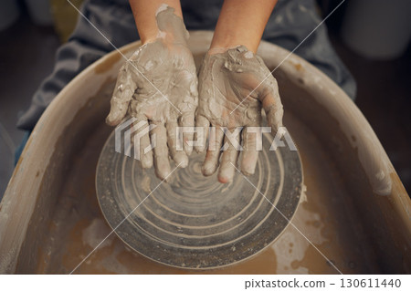 Hands, clay and pottery wheel in a workshop after creating a sculpture or project for a small business. Creative, crafts and artistic sculptor manufacturing handicraft mould products in an art studio Hands, clay and pottery wheel in a workshop after creating a sculpture or project for a small business. Creative, crafts and artistic sculptor manufacturing handicraft mould products in an art studio 130611440