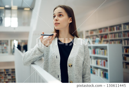Phone, communication and student woman in a library education and learning building talking. Books, girl talking and research conversation of a person in college ready for study and book search Phone, communication and student woman in a library education and learning building talking. Books, girl talking and research conversation of a person in college ready for study and book search 130611445