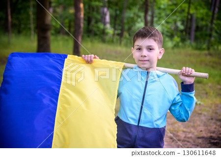 Ukrainian boy with waving flag and praying to stop the war in Ukraine in a field at sunset. War of Russia against Ukraine. Stop War Ukrainian boy with waving flag and praying to stop the war in Ukraine in a field at sunset. War of Russia against Ukraine. Stop War 130611648