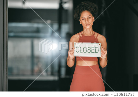 Fitness, portrait or personal trainer at gym with a closed sign for workout exercises or training. Manager, bankruptcy or serious black woman holding a board to stop exercising in empty health club 130611755