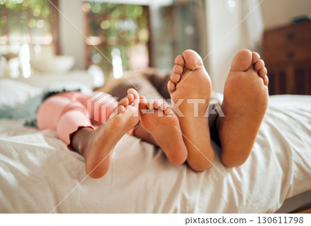 Family, bed and feet of father and girl enjoying quality time, holiday and freedom on weekend together. Love, home lifestyle and dad with child in bedroom to relax, bonding and happiness in morning 130611798