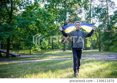 Pray for Ukraine. boy with Ukrainian flag running the summer park. Little kid waving national flag praying for peace. Happy child celebrating Independence Day Pray for Ukraine. boy with Ukrainian flag running the summer park. Little kid waving national flag praying for peace. Happy child celebrating Independence Day 130611878