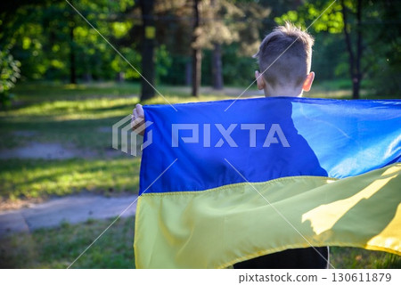 Pray for Ukraine. boy with Ukrainian flag running the summer par Pray for Ukraine. boy with Ukrainian flag running the summer par 130611879