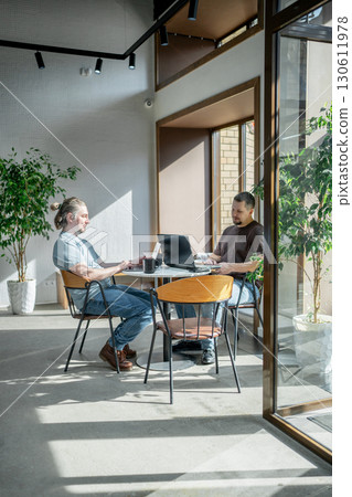 Two It Software engineers working on project and programming in coffee shop. Business people concept. Two It Software engineers working on project and programming in coffee shop. Business people concept. 130611978