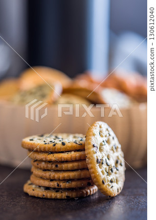 Crispy round salted crackers on black table. Crispy round salted crackers on black table. 130612040