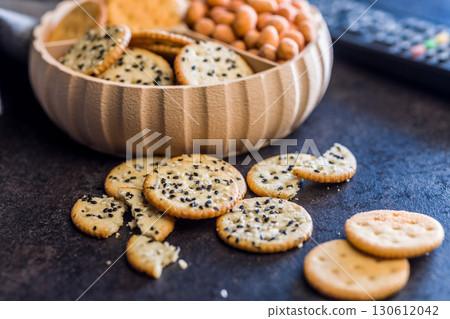 Crispy round salted crackers on black table. Crispy round salted crackers on black table. 130612042