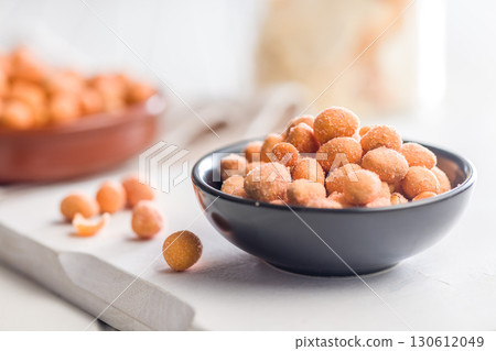 Peanuts in a crispy crust in bowl on white table. 130612049