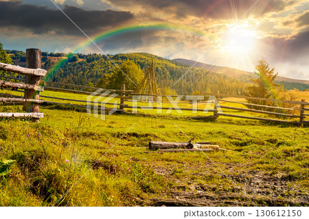 mountainous rural landscape in autumn at sunset. wooden fence near the path through grassy meadow on the hillside. scenery with fir forest on the mountains in evening light under sky with clouds mountainous rural landscape in autumn at sunset. wooden fence near the path through grassy meadow on the hillside. scenery with fir forest on the mountains in evening light under sky with clouds 130612150