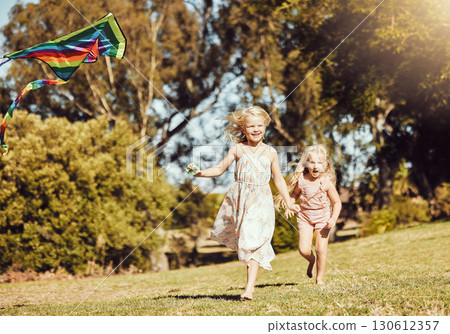 Kite, running and children running in an outdoor park with summer fun and smile. Nature, kids vacation and happiness of kids ind sunshine with freedom and smiling bonding together on green grass 130612357