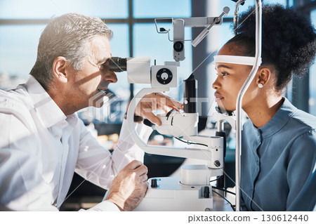 Test, eye exam or black woman consulting doctor for eyesight at optometrist or ophthalmologist. African customer testing vision with mature optician helping or checking iris or retina visual health Test, eye exam or black woman consulting doctor for eyesight at optometrist or ophthalmologist. African customer testing vision with mature optician helping or checking iris or retina visual health 130612440