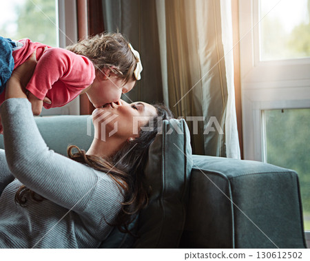 Relax, happy and kiss with mother and baby on sofa for bonding, quality time and child development. Growth, support and trust with mom and daughter in family home for health, connection and care 130612502