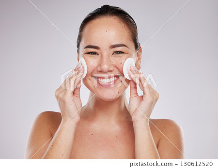 Face portrait, skincare cotton and Asian woman in studio isolated on a gray background. Makeup hygiene, beauty dermatology and happy female model with facial pad or product for cleaning cosmetics. Face portrait, skincare cotton and Asian woman in studio isolated on a gray background. Makeup hygiene, beauty dermatology and happy female model with facial pad or product for cleaning cosmetics. 130612520