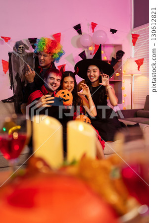 Dinner and group of people celebrating together at Halloween party. 130612821