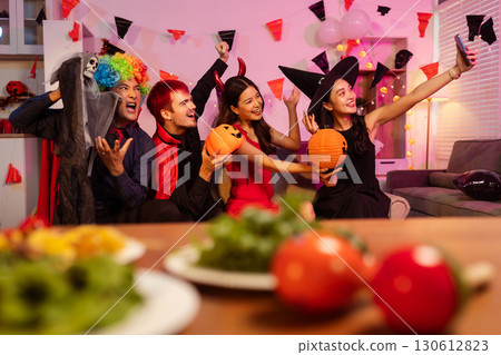 Dinner and group of people celebrating together at Halloween party. 130612823