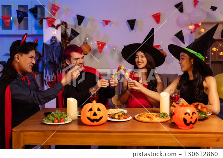 Dinner and group of people celebrating together at Halloween party. Dinner and group of people celebrating together at Halloween party. 130612860
