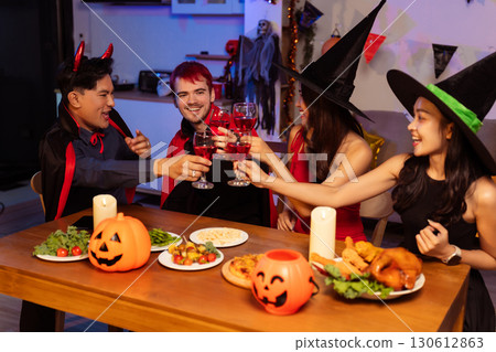 Dinner and group of people celebrating together at Halloween party. 130612863