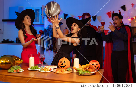 Dinner and group of people celebrating together at Halloween party. Dinner and group of people celebrating together at Halloween party. 130612881