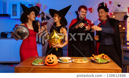 Dinner and group of people celebrating together at Halloween party. 130612886