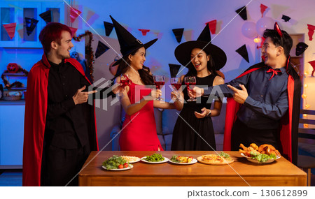 Dinner and group of people celebrating together at Halloween party. 130612899