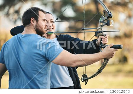 Archery, bow and shooting range sports training with a woman and man outdoor for target practice. Archer and athlete person with focus on field for competition or game to aim arrow for action 130612943