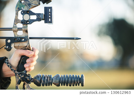 Archery bow and closeup of person at shooting range for competition, game or learning in field or outdoor sports. Woman and arrow for gaming, adventure and sport hunting with aim and target practice Archery bow and closeup of person at shooting range for competition, game or learning in field or outdoor sports. Woman and arrow for gaming, adventure and sport hunting with aim and target practice 130612963