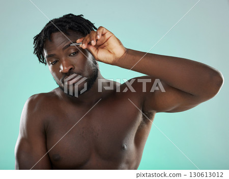 Black man, studio and tweezer for eyebrows, cosmetic beauty and grooming by blue background for wellness. Model, cosmetic and facial hair removal with metal tools for aesthetic, cleaning or self care Black man, studio and tweezer for eyebrows, cosmetic beauty and grooming by blue background for wellness. Model, cosmetic and facial hair removal with metal tools for aesthetic, cleaning or self care 130613012