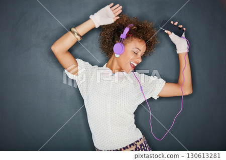 Phone music, dancing singer and black woman listening to song, audio podcast or radio sound for energy, relief or fun. Studio singing, dancer or retro dance student isolated on chalkboard background Phone music, dancing singer and black woman listening to song, audio podcast or radio sound for energy, relief or fun. Studio singing, dancer or retro dance student isolated on chalkboard background 130613281