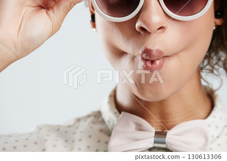 Sunglasses, fashion and face of woman with kiss pose on white background for summer, casual and trendy style. Creative, beauty and zoom of girl isolated in studio for cosmetics, makeup and confidence Sunglasses, fashion and face of woman with kiss pose on white background for summer, casual and trendy style. Creative, beauty and zoom of girl isolated in studio for cosmetics, makeup and confidence 130613306