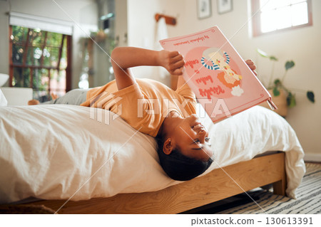 Happy child reading book on bed for home learning, language education and creative development upside down. Smart, intelligent and Indian kid with English story for fun, relax and holiday activity Happy child reading book on bed for home learning, language education and creative development upside down. Smart, intelligent and Indian kid with English story for fun, relax and holiday activity 130613391