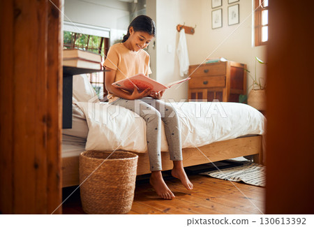 Happy child reading on bed for home learning, language education and creative development in her bedroom. Smart, intelligent and Indian girl kid with English books for fun story and holiday activity Happy child reading on bed for home learning, language education and creative development in her bedroom. Smart, intelligent and Indian girl kid with English books for fun story and holiday activity 130613392