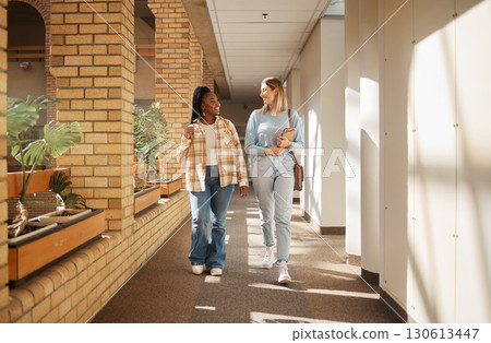 University, friends and women walking, talking and education in hall, conversation and bonding. Young females, girls and students have discussion, walk and share news on campus and happiness outdoor 130613447