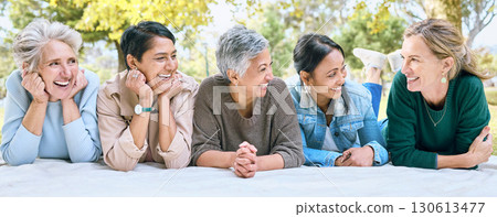 Senior women, friends and relax on picnic in park for bonding, wellness and rest on blanket. Happiness, comic and group of elderly people in retirement talking, laughing and enjoying time in nature. 130613477
