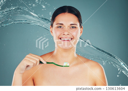 Happy, grooming and portrait of a woman brushing teeth isolated on a blue background. Water splash, health and face of a clean, smiling and young model taking care of dental hygiene with toothpaste Happy, grooming and portrait of a woman brushing teeth isolated on a blue background. Water splash, health and face of a clean, smiling and young model taking care of dental hygiene with toothpaste 130613604