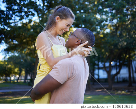 Love, hug and interracial couple at a park, happy and excited against a tree background. Romance, sweet and black man lifting his girlfriend, in love and cheerful in a forest, together and joy Love, hug and interracial couple at a park, happy and excited against a tree background. Romance, sweet and black man lifting his girlfriend, in love and cheerful in a forest, together and joy 130613638