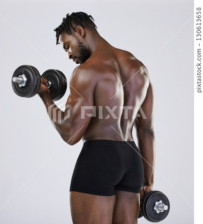 Dumbbell, exercise and fitness of strong black man doing muscle workout in studio. Body of a sexy bodybuilder in underwear training with weights for power, health and wellness or growth motivation Dumbbell, exercise and fitness of strong black man doing muscle workout in studio. Body of a sexy bodybuilder in underwear training with weights for power, health and wellness or growth motivation 130613658