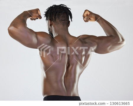 Back, body and biceps with a model black man posing in studio on a gray background for fitness or exercise. Muscle, health and wellness with a strong male athlete standing or flexing for power Back, body and biceps with a model black man posing in studio on a gray background for fitness or exercise. Muscle, health and wellness with a strong male athlete standing or flexing for power 130613665