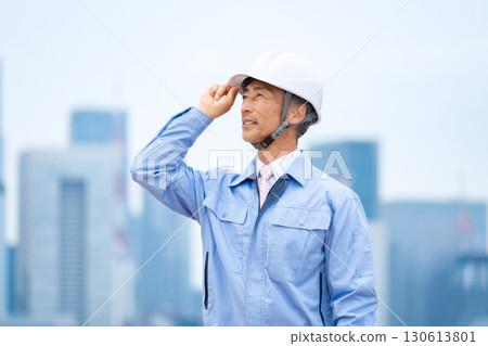 Man in work clothes, helmet, sky, sideways 130613801