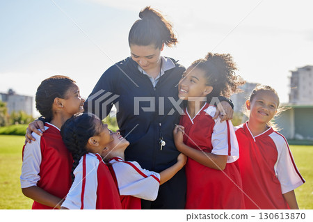 Girl football team, coach celebration and hug for success, teamwork and group diversity on grass pitch. Young female kids, soccer coaching and love for mentor woman on field for happiness in sunshine 130613870