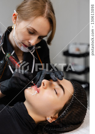 Skilled Artist Performing Lip Tattoo Procedure Skilled Artist Performing Lip Tattoo Procedure 130613898