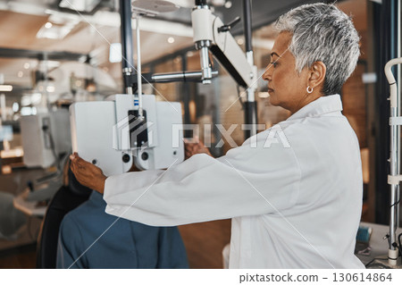 Eye exam, optometry and optometrist woman for vision consultation, medical or healthcare lens expert. Eyes check or consulting client, person or patient with professional doctor and phoropter machine 130614864