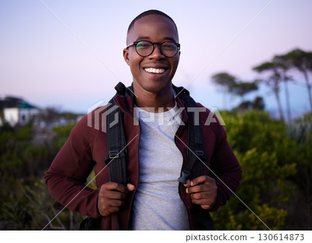 Portrait, hiking and nature with a black man outdoor for health, freedom or adventure in the evening. Hike, hobby and recreation with a handsome young male hiker carrying a backpack alone outside Portrait, hiking and nature with a black man outdoor for health, freedom or adventure in the evening. Hike, hobby and recreation with a handsome young male hiker carrying a backpack alone outside 130614873