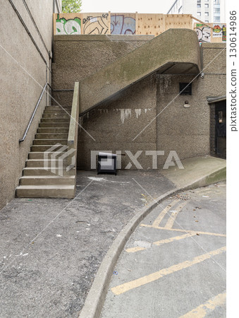 an outdoor concrete area of the Balfron Tower Playground a renowned example of Brutalist architecture located in Poplar, East London, featuring a set of concrete stairs with a metal handrail and a 130614986