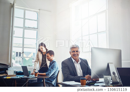 Portrait, business and senior man by computer in office workplace. Pc, coworking and happy elderly male employee working on marketing report, advertising or sales project with colleagues in company. 130615119