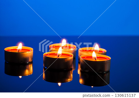 Burning small candles on a blue background Burning small candles on a blue background 130615137