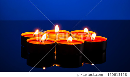 Burning small candles on a blue background 130615138