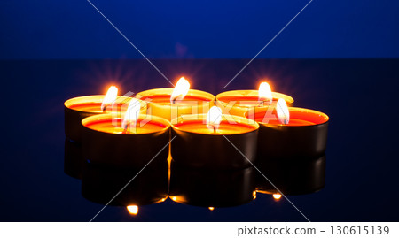 The darkness melts in the glow of dozens of candles The darkness melts in the glow of dozens of candles 130615139