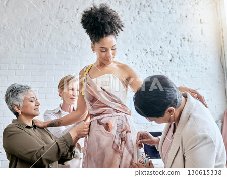 Designer women, model and fitting dress for focus, design or teamwork for runway fashion in workshop. Happy team, woman collaboration and success vision for diversity, goals or helping hand in studio Designer women, model and fitting dress for focus, design or teamwork for runway fashion in workshop. Happy team, woman collaboration and success vision for diversity, goals or helping hand in studio 130615338