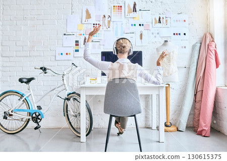 Designer woman, music and desk in workshop by moodboard, relax and dance on break for inspiration. Startup fashion expert, studio and sitting at table for motivation, vision or goal with headphones Designer woman, music and desk in workshop by moodboard, relax and dance on break for inspiration. Startup fashion expert, studio and sitting at table for motivation, vision or goal with headphones 130615375