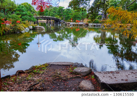 Kyoto Shosei-en Garden: Sensetsu Bridge over Ingetsu Pond and Kyoto Tower reflected in the water 130615580