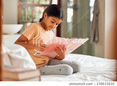 Smart child reading story for home learning, language and creative education development on her bed. Happy, kindergarten Indian girl kid with English books for knowledge, hobby and fun house activity 130615620